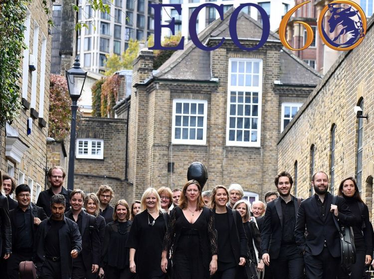 The English Chamber Orchestra walk along a street in black clothes towards the camera The English Chamber Orchestra walk along a street in black clothes towards the camera